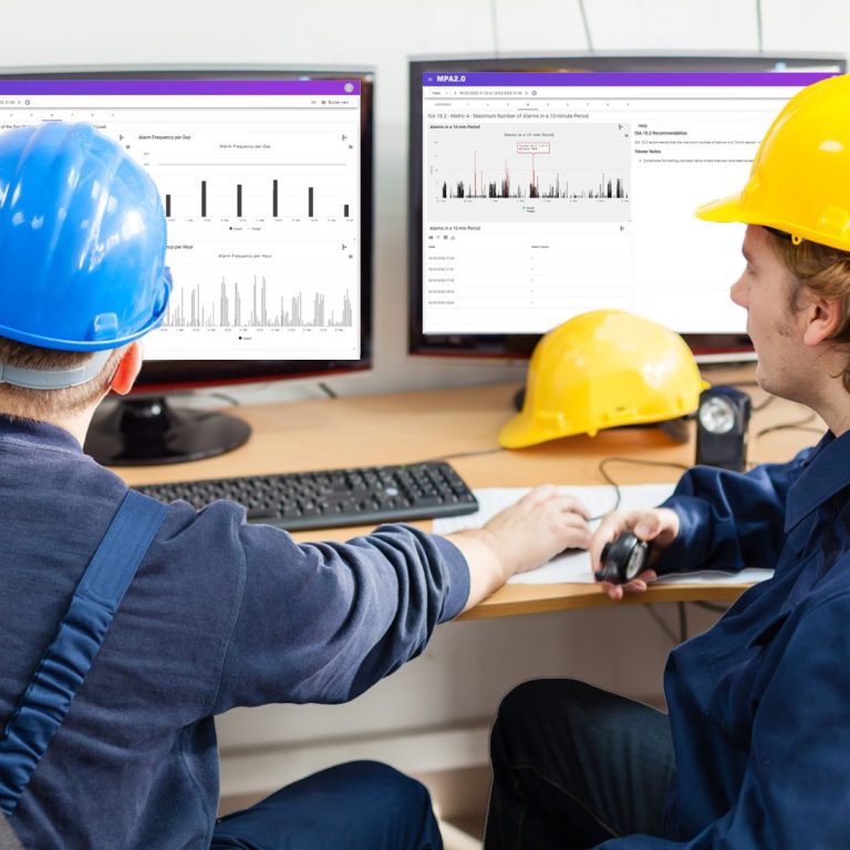 two men in hard hats using alarm manager on computers