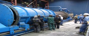 Operators standing in front of a blue ISAMILL piece of machinery