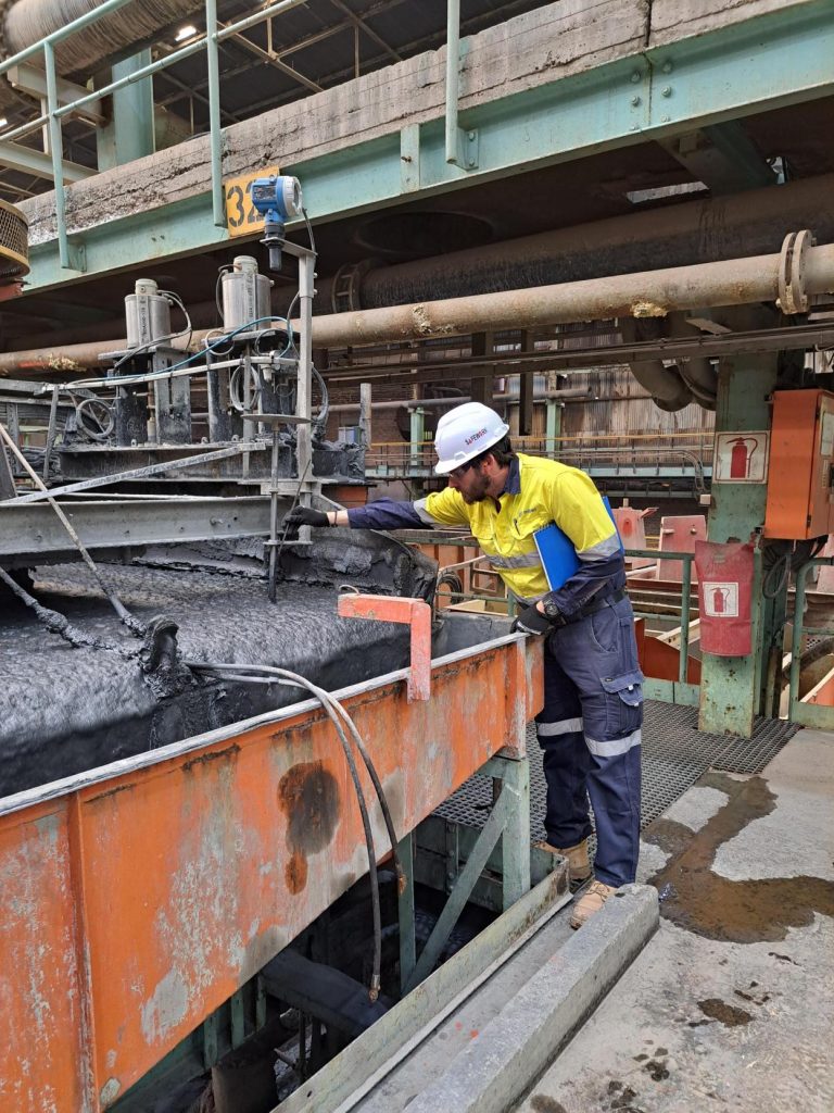 Man in high vis looking at something on a mine site