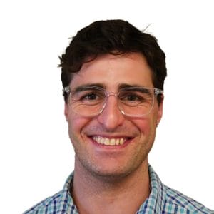 Man's profile image on white background. The man has dark hair and glasses and is wearing a blue checkered shirt.