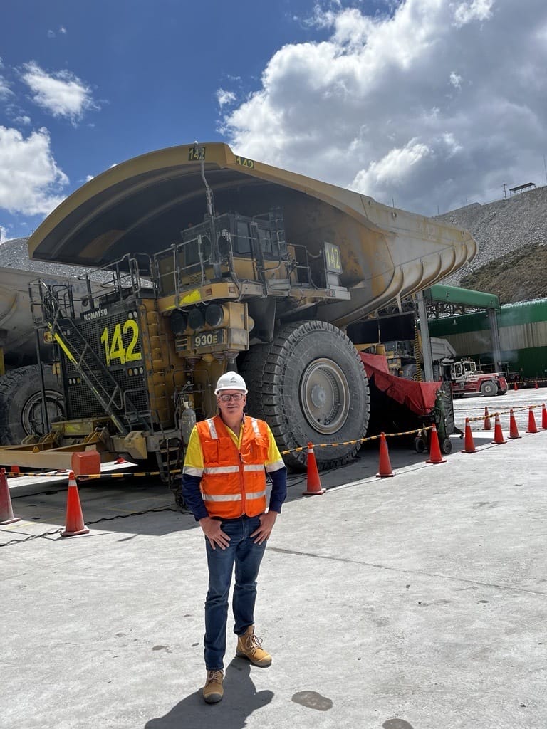 Man in high vis standing in front of a mine truck