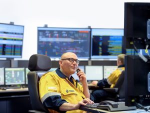 man in control room looking at computers