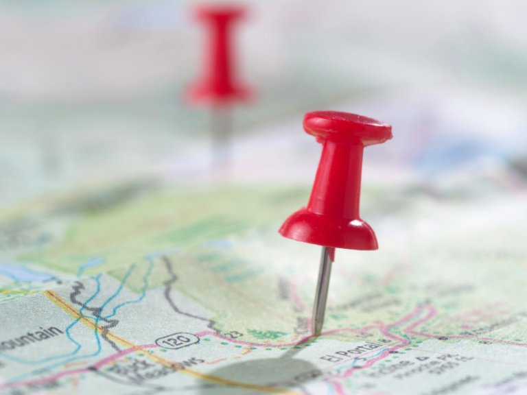 Close up picture of a map with two red pins on it, showing a direction. Digital transformation roadmaps can provide a strategic, iterative approach to digital transformation.