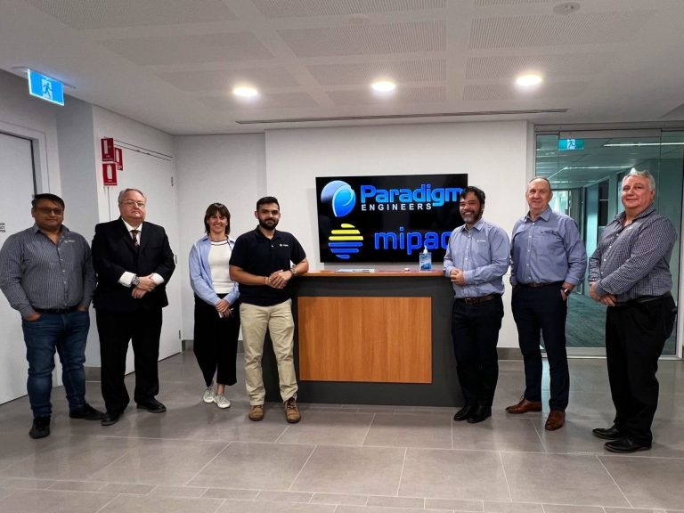 Group of people standing in a lobby, in front of a sign